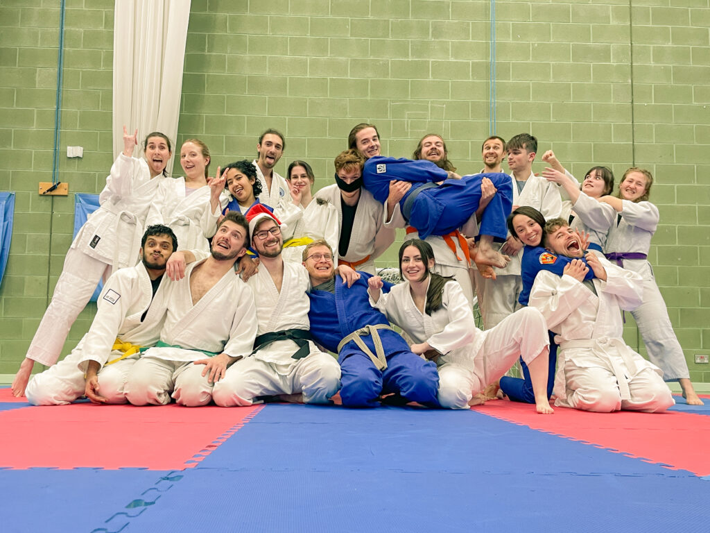 Get in contact - friendly group of jiu jitsu students doing silly poses